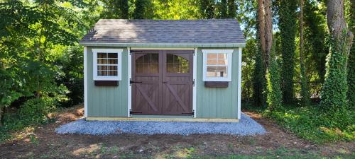 LISB-Huntington-10x14-cape-sagebrush-green-navajo-trim-teak-roof-padre-brown-carriage-house-doors-brown-flowerboxes